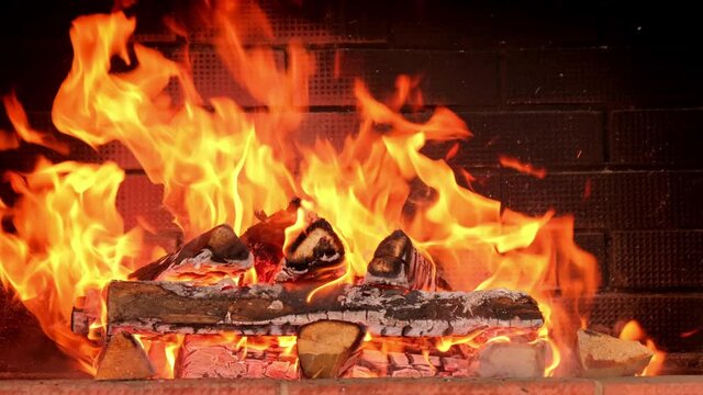 Fire is burning in the fireplace. Firewood. red coals of burned wood in the oven. Wood fire and flame close up. Flames of a country house. Warmth and home comfort. 4k footage