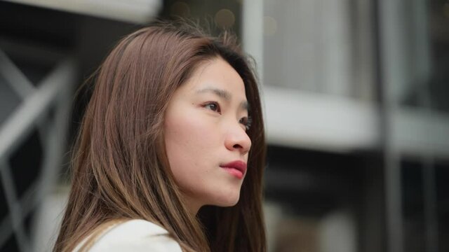 4k slow motion of young asian business woman in white suit looking out serious unsmiling attractive beautiful asian businesswoman close up portrait