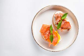Juicy tomatoes and fresh fruit with carpaccio meat on fresh bread, sauce as topping. Traditional Italian cuisine.