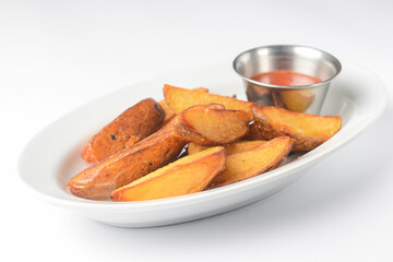Roasted or baked potatoes with rosemary in a white bowl. Potatoes in rural style served with sauce.
