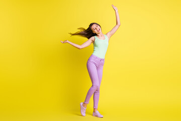 Fototapeta na wymiar Photo of inspired girl dance close eyes wear green singlet purple pants footwear isolated yellow color background