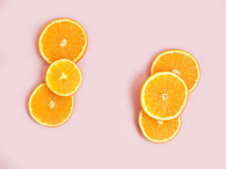 Orange slices frame on pink background with copy space. Empty place for text and product. Flatlay, top view.