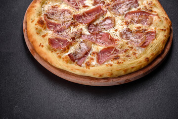 Delicious fresh crispy pizza from the oven with ham, cheese and basil