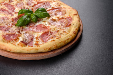 Delicious fresh crispy pizza from the oven with ham, cheese and basil