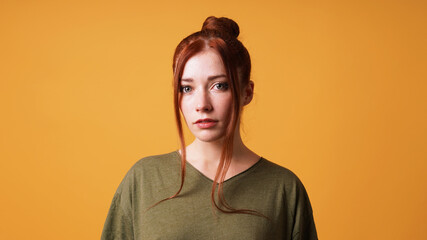portrait of pretty young woman with red hair bun and curtain bangs