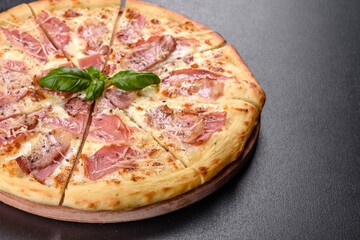 Delicious fresh crispy pizza from the oven with ham, cheese and basil