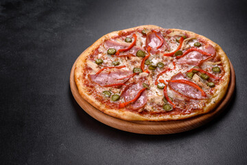 Delicious fresh crispy pizza from the oven with ham and Bulgarian pepper