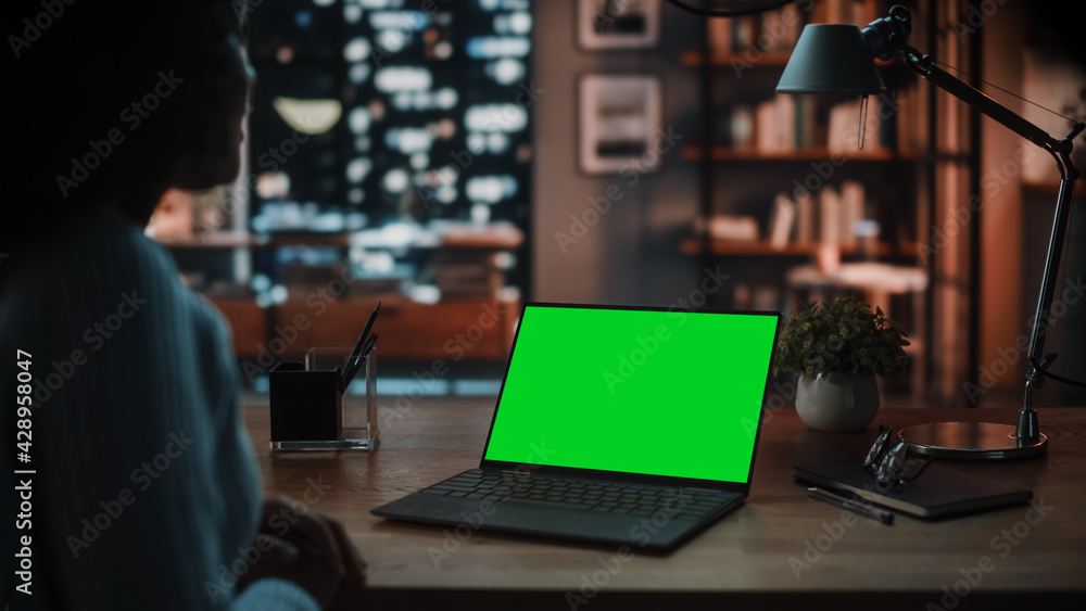Poster close up female specialist making a video call on laptop with green screen mock up display at home l