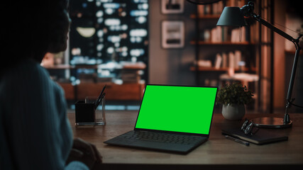 Close Up Female Specialist Making a Video Call on Laptop with Green Screen Mock Up Display at Home Living Room while Sitting at a Table. Freelancer Chatting Over the Internet on Social Networks.