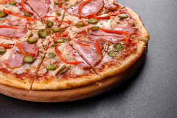 Delicious fresh crispy pizza from the oven with ham and Bulgarian pepper