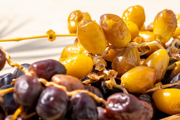 Holy Muslim Ramadan fasting concept: Close up on many brown and yellow date fruits. Vegan food background with copy space. Nobody. Sweet traditional snack. Organic and healthy berry 