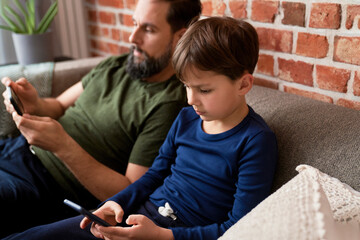 Close up of father and son using mobile phone