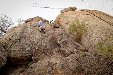 Little boy climbing rocks in beautiful rocky landscape in Pyramid Hill, Victoria Australia