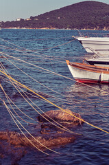 Wooden boats tied To pier , an island at background with retro filter.
