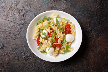 Pasta with cherry tomatoes, soft cheese and arugula leaves