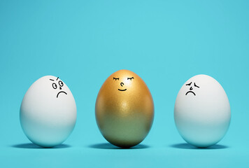 Golden egg with a funny smiling face among the white eggs. Concept of exclusivity, best choice,...