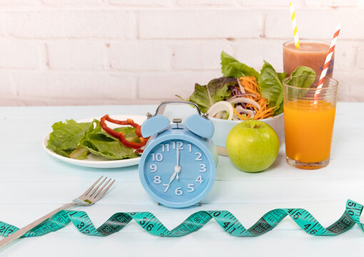 Selective focus of blue clock which Intermittent  fast program  concept and healthy food for diet plan image
