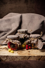 Jars of drying and candy stand on a wooden board on a brown background
