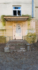door to the old abandoned ruined dirt building in the city center close-up