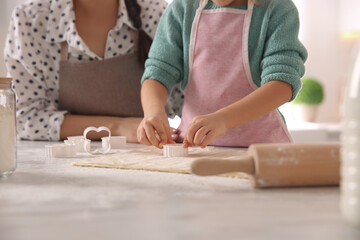Fototapeta na wymiar Mother and daughter making pastry in kitchen at home, closeup