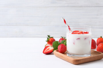 Delicious drink with strawberries on white wooden table. Space for text