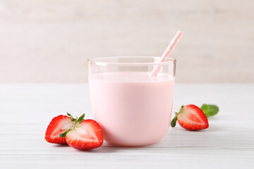Delicious drink with strawberries on white wooden table