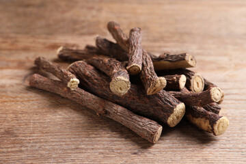 Dried sticks of liquorice root on wooden table, closeup