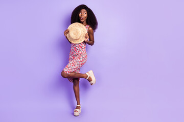 Full size profile photo of nice impressed curly brown hairdo lady look empty space wear colorful dress isolated on violet background