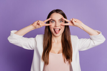 Close up portrait of lady show two v-sign cover eyes protrude tongue wear formal suit posing on purple wall