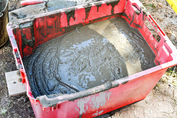 Cement mortar in the plastic pallet is prepared for side work. Construction side works.