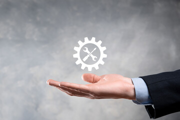 Businessman holding gear icon with tools.Gearing.Concept of target focus digital diagram,graph interfaces,virtual UI screen,connections netwoork.