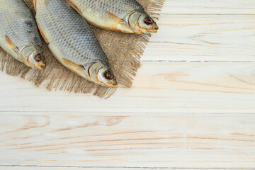 dry fish on a white wooden background with room for text.