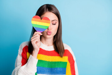 Portrait of attractive dreamy girl closing eye striped heart sending air kiss copy space isolated...