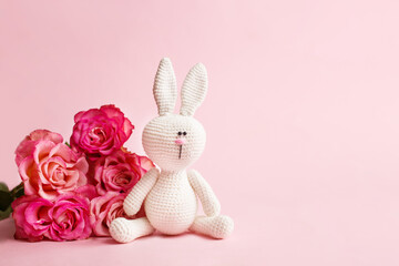 Mother's Day greeting card concept. Amigurumi rabbit, roses flowers on pink pastel background