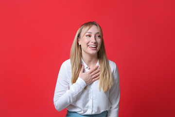 Beautiful young woman laughing on red background. Funny joke