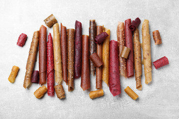 Delicious fruit leather rolls on grey table, flat lay
