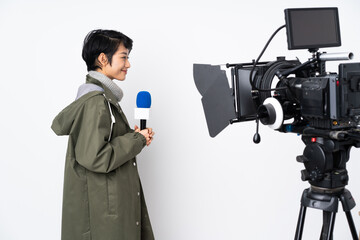 Reporter Vietnamese woman holding a microphone and reporting news in lateral position