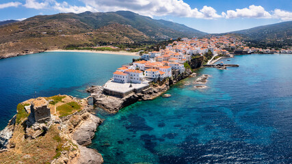 Aerial view to the idyllic town of Andros island, with the fortress by the turquoise sea, Cyclades, Greece