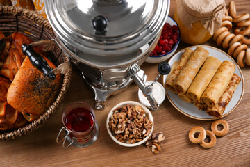 Traditional Russian samovar and treats on wooden table, top view