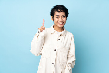 Young Vietnamese woman with short hair over isolated background pointing up a great idea