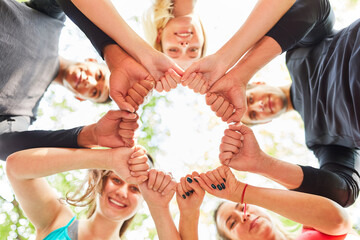 Group of teenagers in a circle with clenched fists