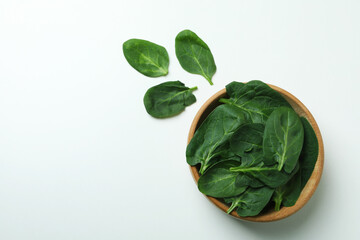 Bowl of spinach leaves on white background