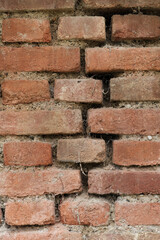 Nahaufnahme im Hochformat einer alten schmutzigen Ziegel-Mauer (Textur / Hintergrund / Deko) aus roten Ziegelsteinen