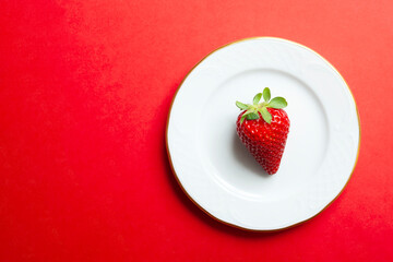 strawberry isolated on a plate with red background. Copy space.