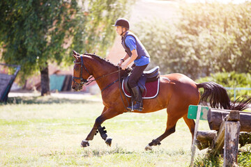 Young man riding horse on cross-country course