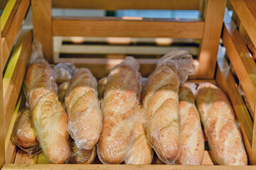 Food background baguettes on a wooden shelf in a store, bread close-up