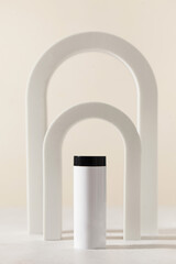 Bottle with hair powder against white backdrop of arches against beige pastel background