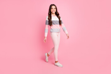 Fototapeta na wymiar Full length photo of charming happy positive girl walk free time good mood isolated on pastel pink color background