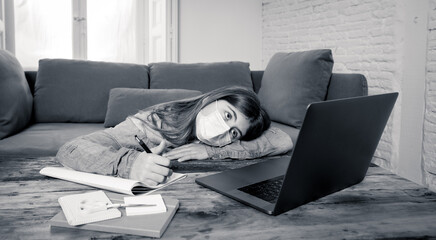 Coronavirus school closures and lockdown. Bored kid with face mask studying online class at home