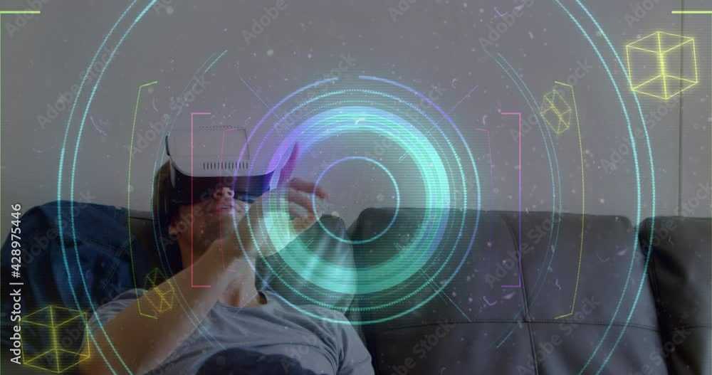 Poster light trails and scope scanning over caucasian man gesturing while wearing vr headset at home